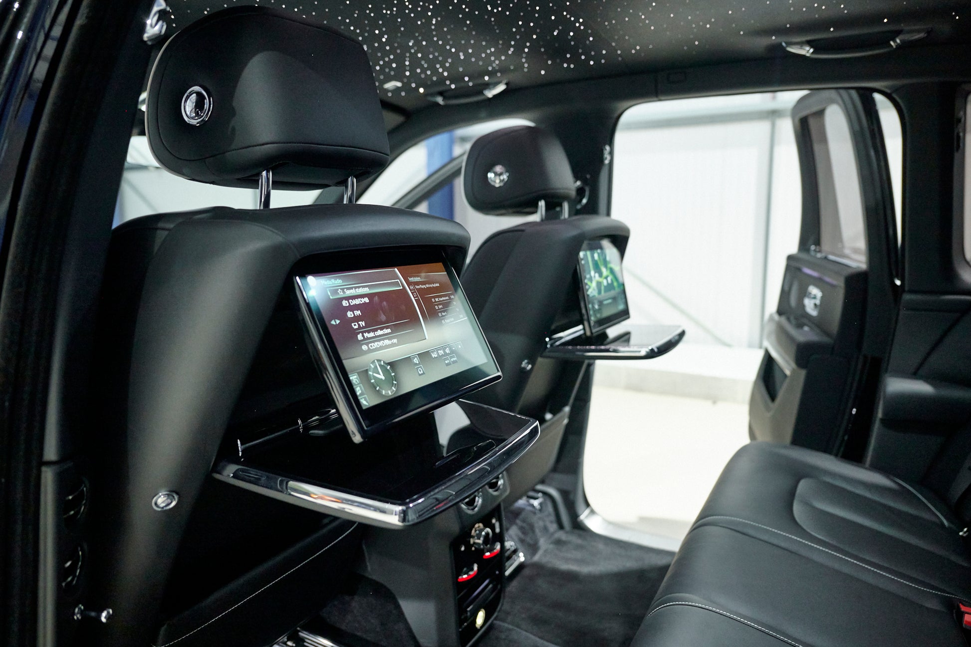 Luxury vehicle interior with entertainment screens and headrests